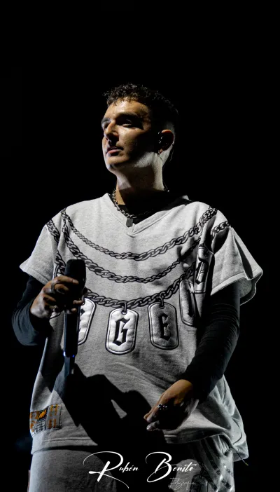 Uno de los artistas de Hijos de la Ruina, micrófono en mano y camiseta gris con cadenas, en el Multiusos Sánchez Paraíso