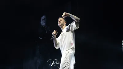 Integrante de Hijos de la Ruina, vestido de blanco, canta con el brazo en alto en el Multiusos Sánchez Paraíso de Salamanca